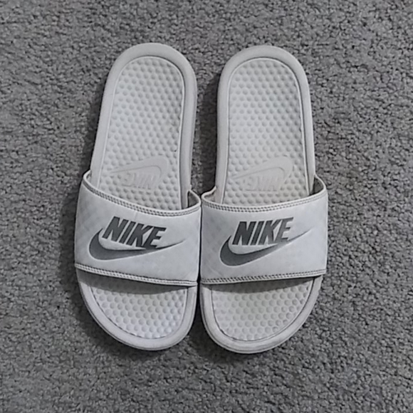 white and silver nike slides